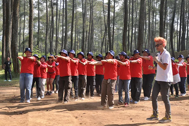 Keseruan peserta mengikuti kegiatan outbound di batu dengan latar belakang hutan pinus coban rondo